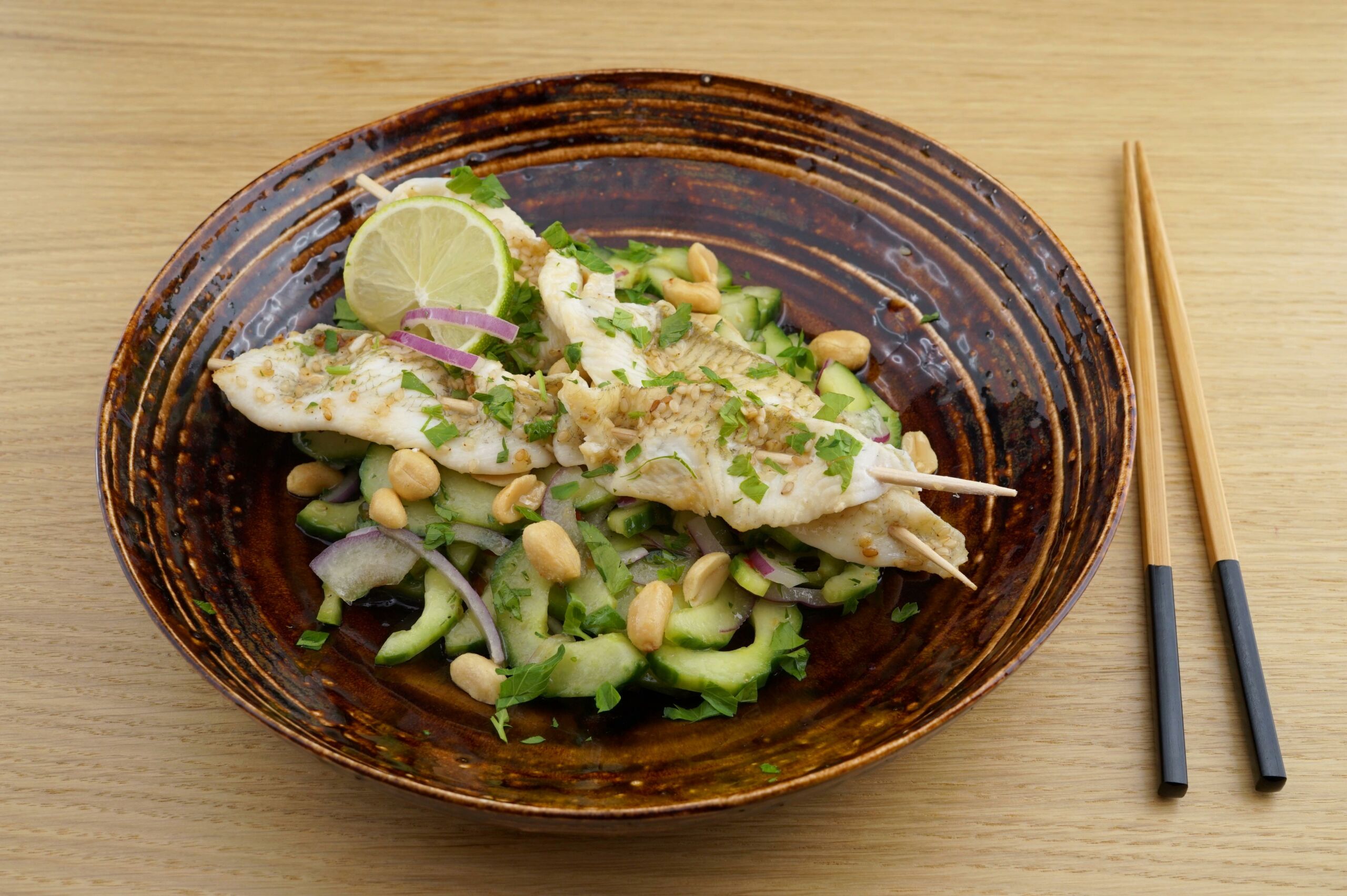 Thai-Gurkensalat mit Erdnuss[-]öl und Fisch[-]spießen